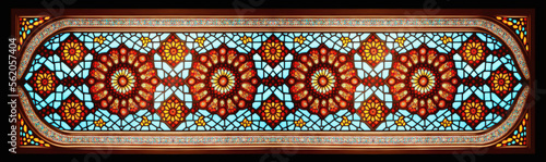 horizontal arabesque pattern with mosaic glass style window, in red and orange back lit colors photo