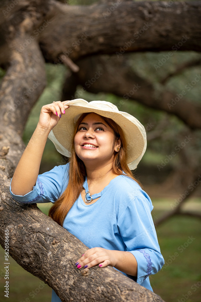Young indian woman wearing hat and giving expression at park