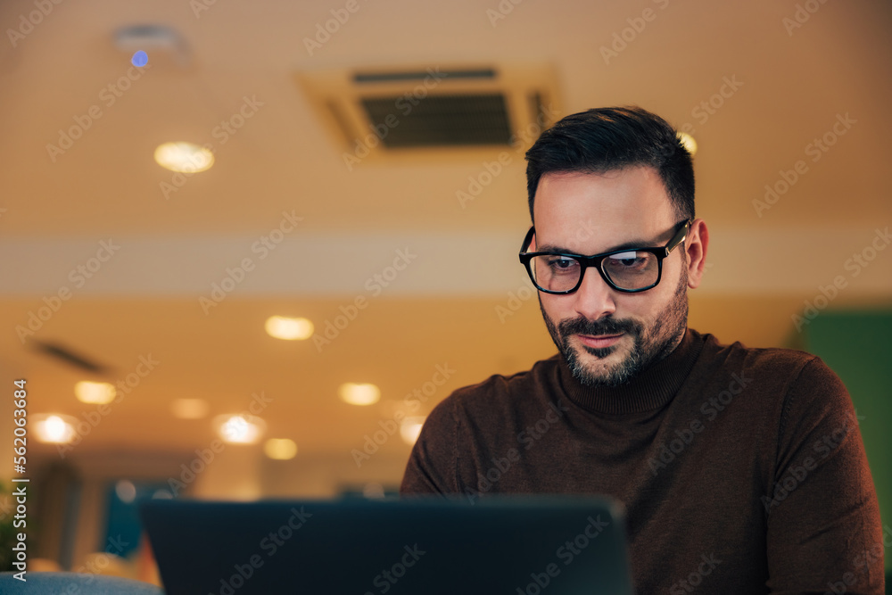 Close-up of a focused businessman, using a laptop, sitting at the workplace. Close-up of a focused businessman, using a laptop, sitting at the workplace.