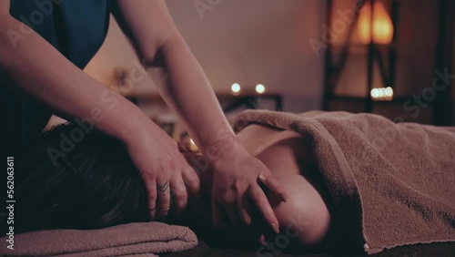 Wallpaper Mural A female masseur with strong hands massages the shoulders and neck of a gentle girl lying on a massage table. Burning candles on the background. Beautiful lighting. Meditation and relaxation. Torontodigital.ca