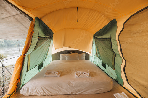 Inside of large comfortable camping tent on campground in the tropical forest by riverside on vacation