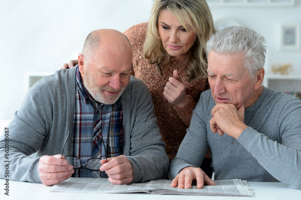 senior people sitting at table and reading newspaper senior people sitting at table and reading newspaper
