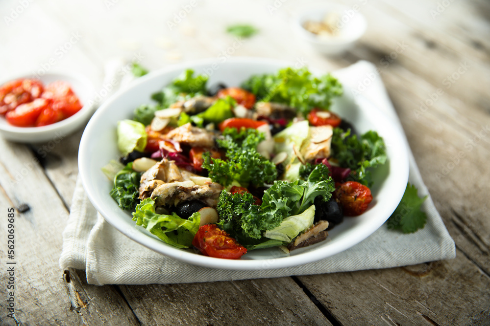 Healthy green salad with roasted tomatoes and fish