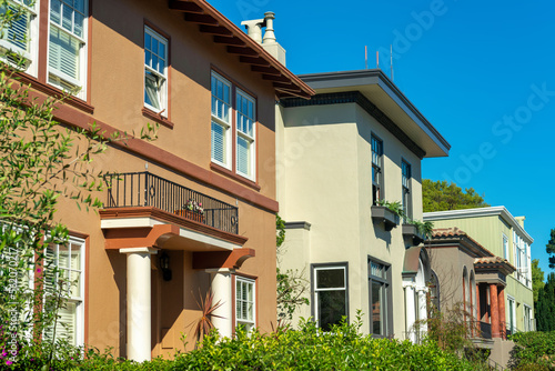 Row of brown beige and green house exteriors or facades in downtown neighborhood in suburban area of the city