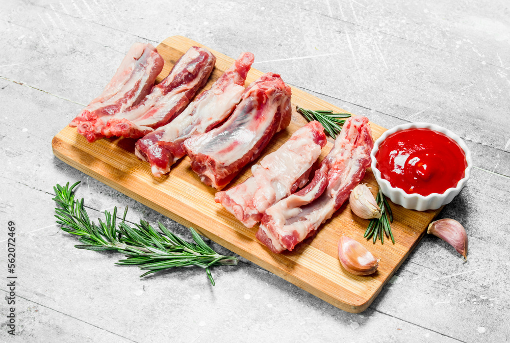 Raw ribs with tomato sauce and fragrant rosemary .