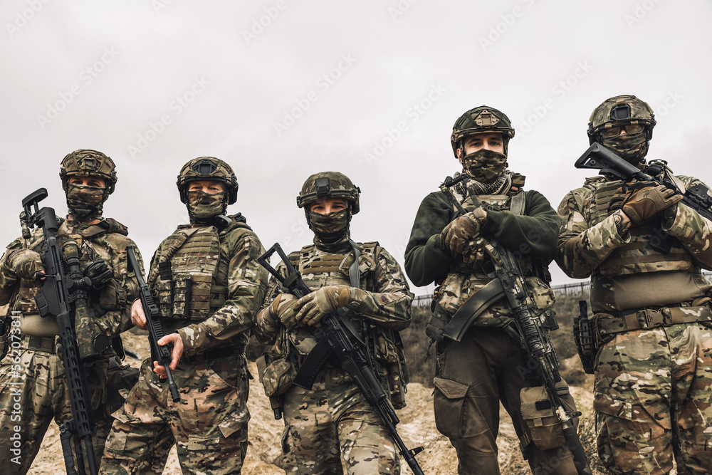 Group of soldiers in camouflage with rifles in hands Group of soldiers in camouflage with rifles in hands