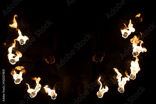 Fireshow in dark. Two steel fans with hot flames. photo