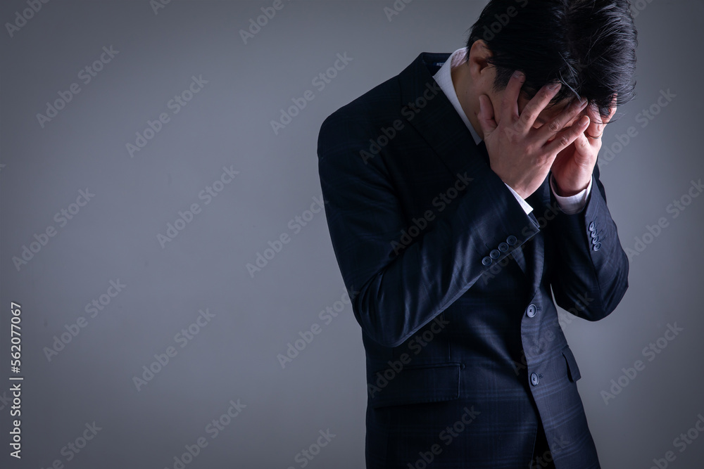 顔を覆うスーツの男性 顔を覆うスーツの男性