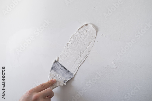 repairing walls with putty and spatula photo