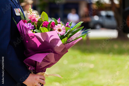 Person presenting flowers to lay on remembrance day photo