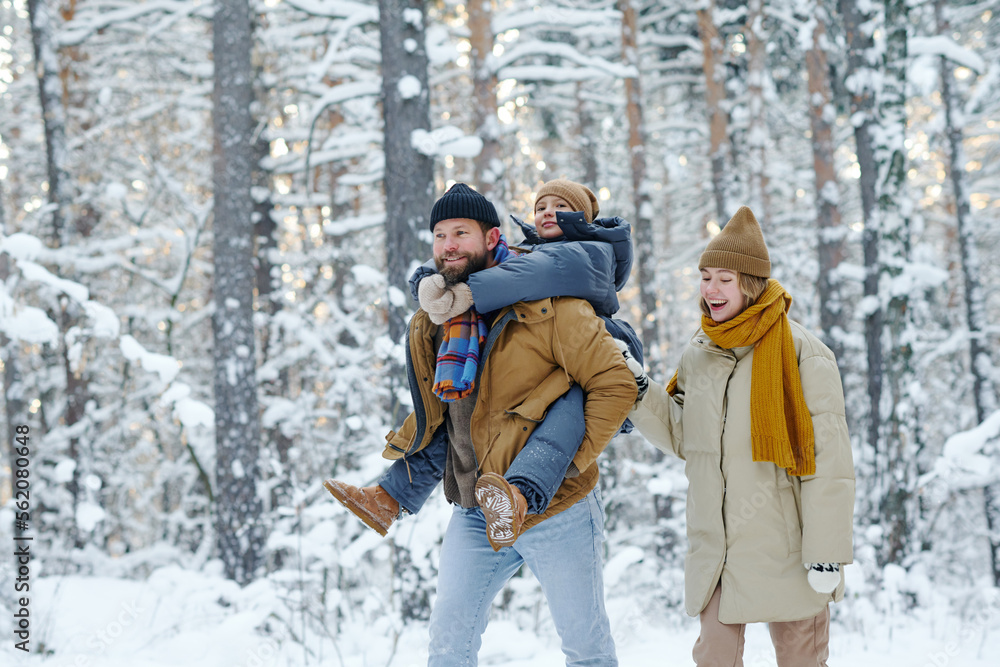 Happy family walking with child in the forest during winter day Happy family walking with child in the forest during winter day
