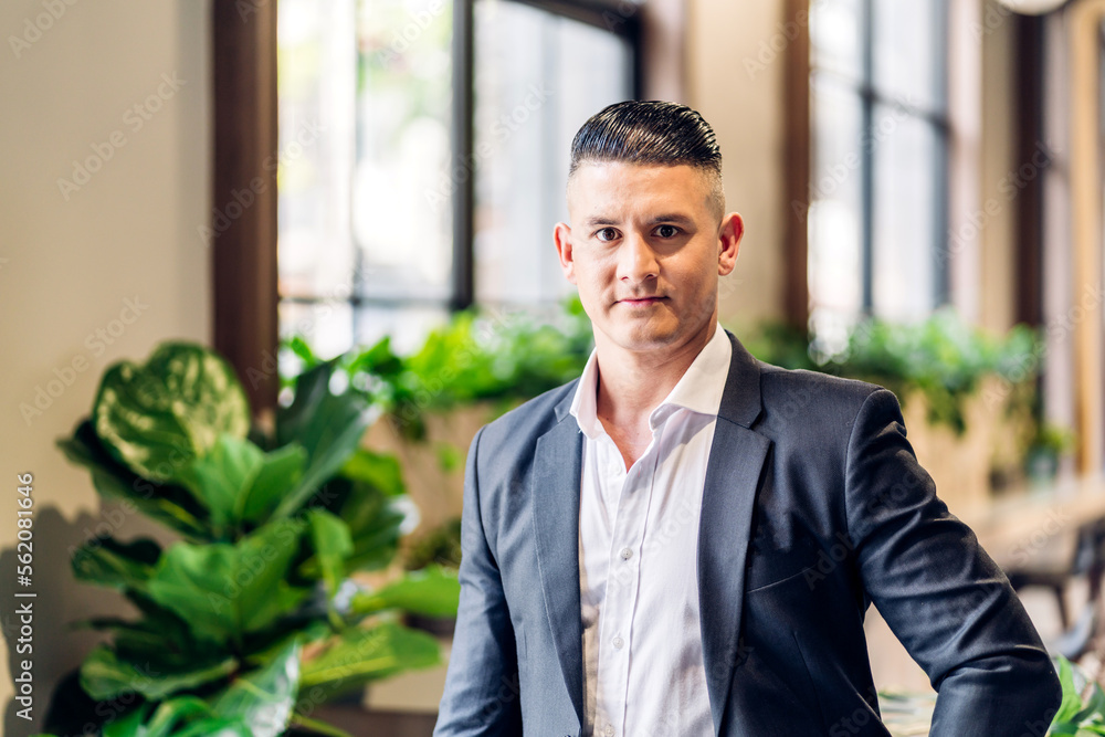 Portrait of confident handsome businessman smiling smart looking at camara.Young creative coworkers business people working and planning at office Portrait of confident handsome businessman smiling smart looking at camara.Young creative coworkers business people working and planning at office