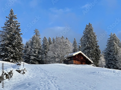 Old traditional swiss rural architecture and alpine livestock farms in the winter ambience over the Lake Walen or Lake Walenstadt (Walensee) and in the Swiss Alps, Amden - Switzerland / Schweiz © Mario