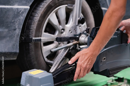 Technical man repairs, maintenance, and set the wheel center, check balance of wheel for safety. Automobile set the wheel center in the car service center. repairman use tools set the wheel center. © Mdisk
