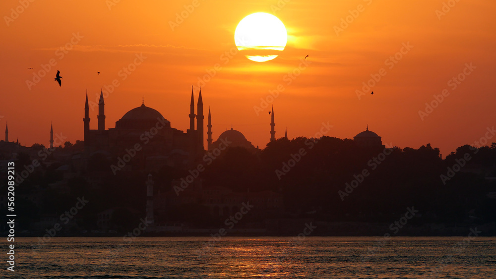 The beautiful Istanbul skyline at sunset from Kadikoy.  Deep orange sunset