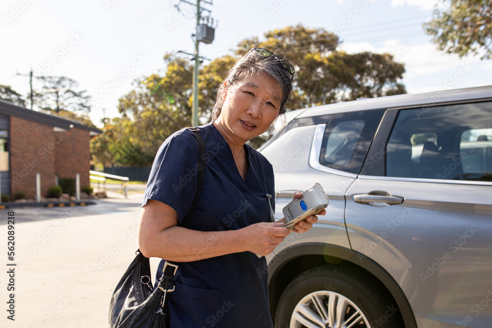 Nurse walking towards the car smiling at the camera Nurse walking towards the car smiling at the camera