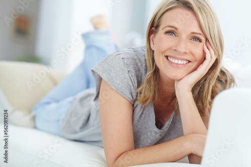 Εκτύπωση καμβά Portrait of mature woman lying on sofa in living room, happiness and relaxing in comfort at home