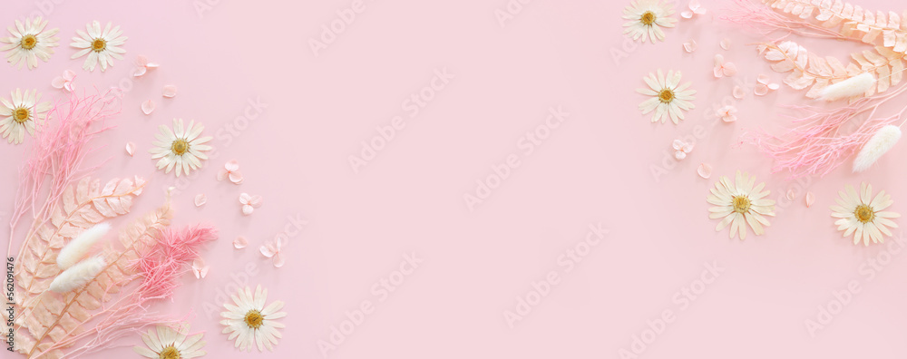 Fototapeta premium Top view image of pink dry flowers over pastel background .Flat lay