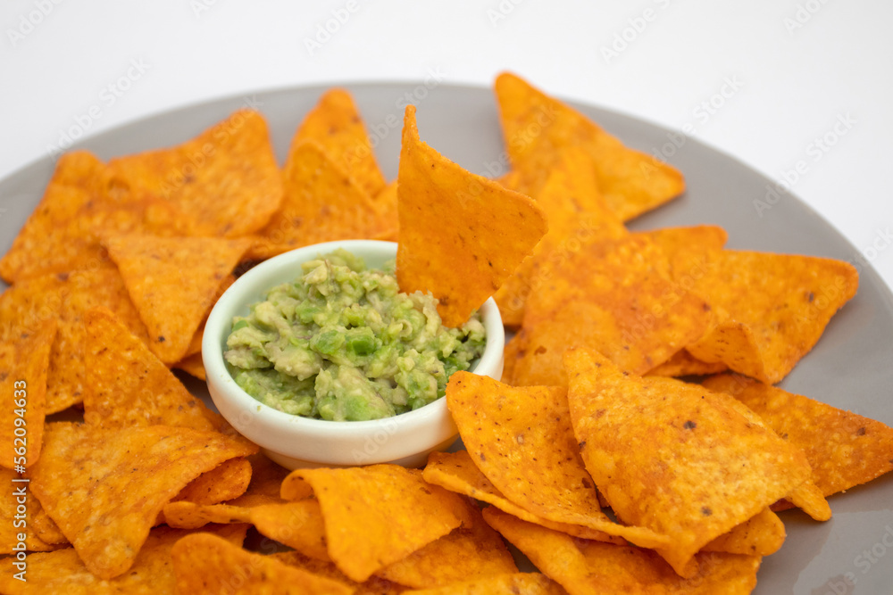 Guacamole dip and nachos chips on white background Guacamole dip and nachos chips on white background