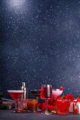 Valentine day romantic bar background. Set various red, pink, chocolate alcohol drinks for Valentine day party or dating, in different cocktail glasses with rose flower bouquet, heart decor, gift box