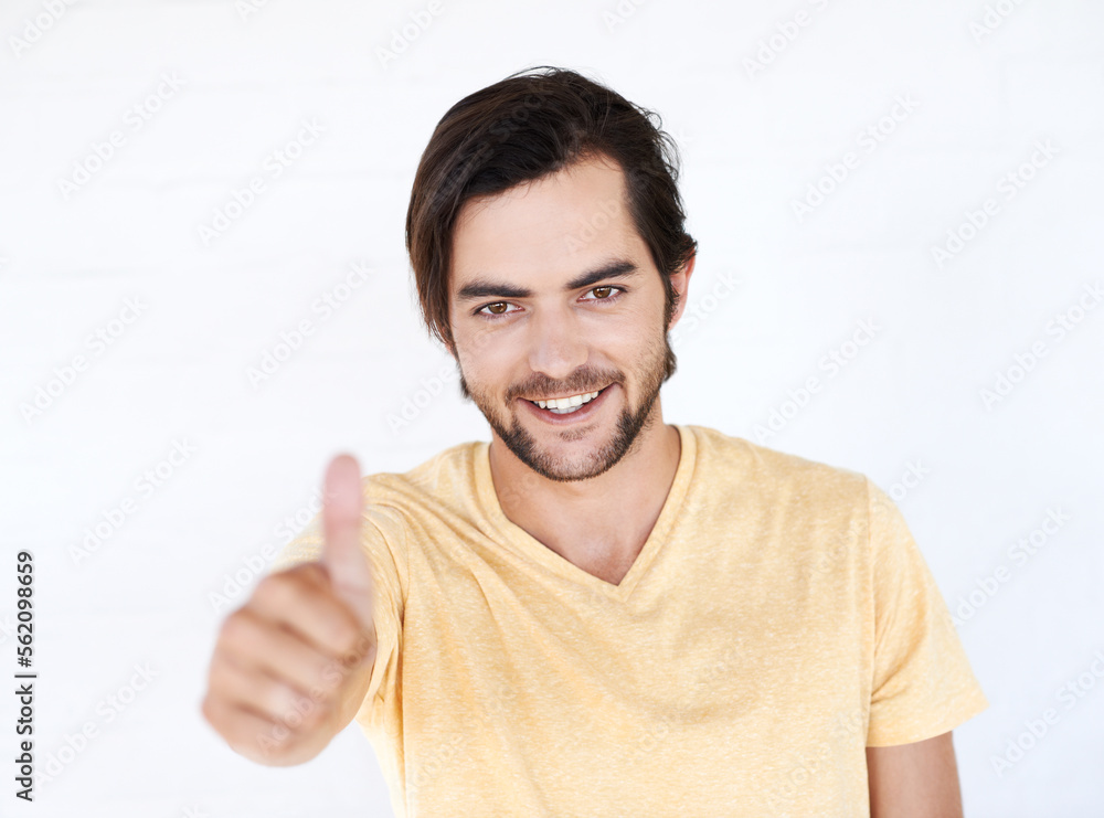 Naklejka premium Thumbs up, winner and portrait of man in studio, white background or isolated emoji. Male model, thumb up and support of yes agreement, celebration and hand sign, vote or trust, thank you and success
