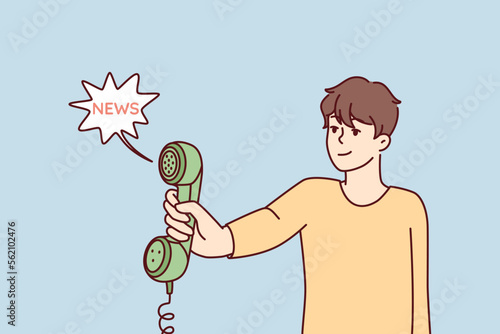 Man holds out landline phone to share news or important information. Handset with wire in hand of young guy who received call from municipal notification service. Flat vector illustration
