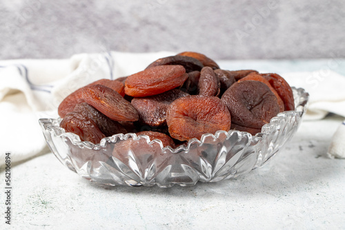 Dried apricots on stone background. Dark dried apricots in a glass bowl. Diet foods. close up photo