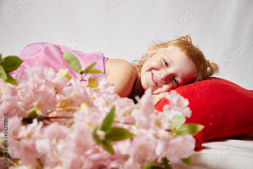 Portrait of cute kid girl posing in pink beautiful dress on a white background. Young female model looking as magic princess from fairy taly