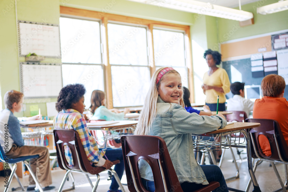 Obraz premium Classroom, children and education portrait of a girl writing to learn, study and gain knowledge. Diversity group students or kids in language class while learning for future, development and growth