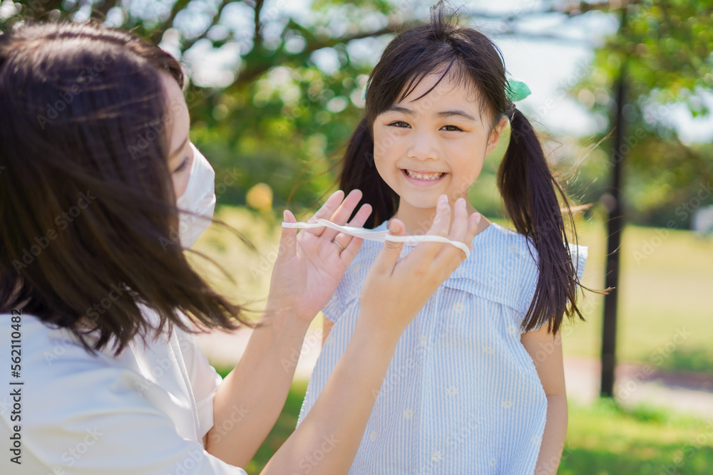 Obraz premium 子どもにマスクを付けさせるお母さん