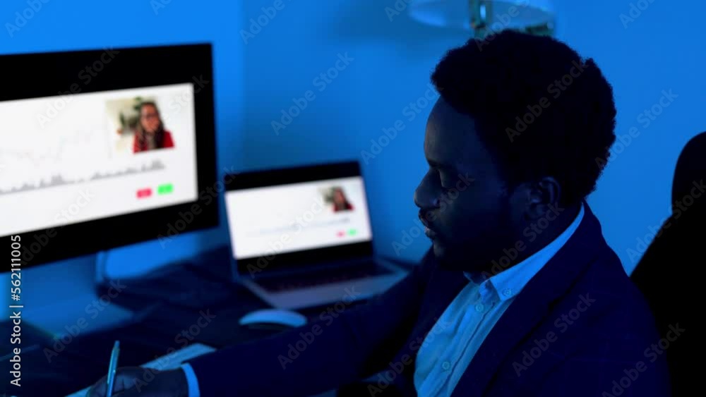 Trader african business man working inside office at night time doing video call meeting
Trader african business man working inside office at night time doing video call meeting