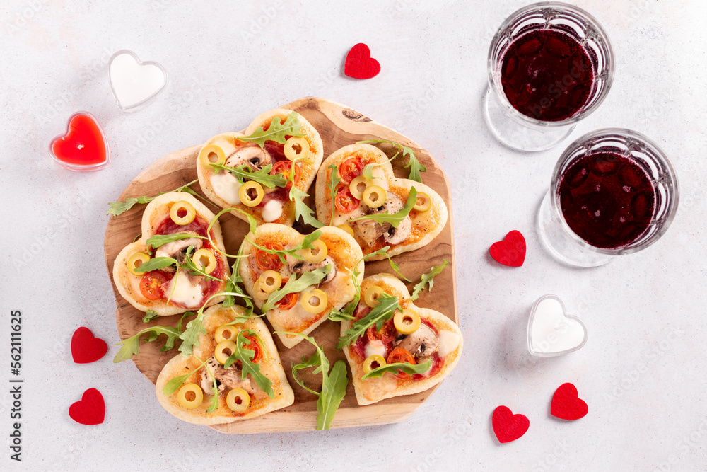 Heart shape mini pizzas on wooden board for Valentines day holiday, top view Heart shape mini pizzas on wooden board for Valentines day holiday, top view