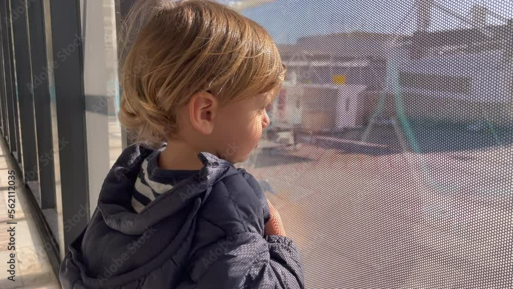 Baby boy standing by window at airport looking at planes Baby boy standing by window at airport looking at planes