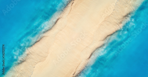 Aerial view of transparent blue sea with waves on the both sides and empty sandy beach at sunset. Top view of sandbank. Summer travel in Zanzibar, Africa. Tropical landscape with white sand and ocean © den-belitsky
