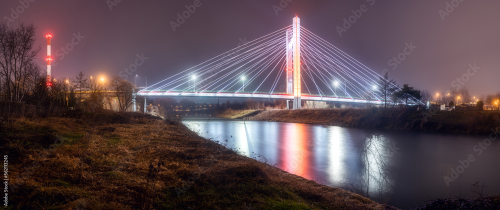 Obraz premium Brama Przemyska. Oświetlony nocą most w Przemyślu nad rzeką San.