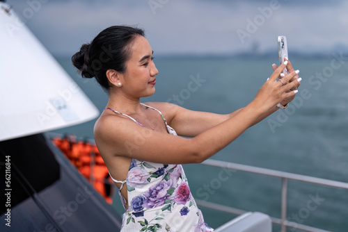 Beautiful girl have fun sailing in the sea sitting on yacht deck enjoy amazing view and selfie