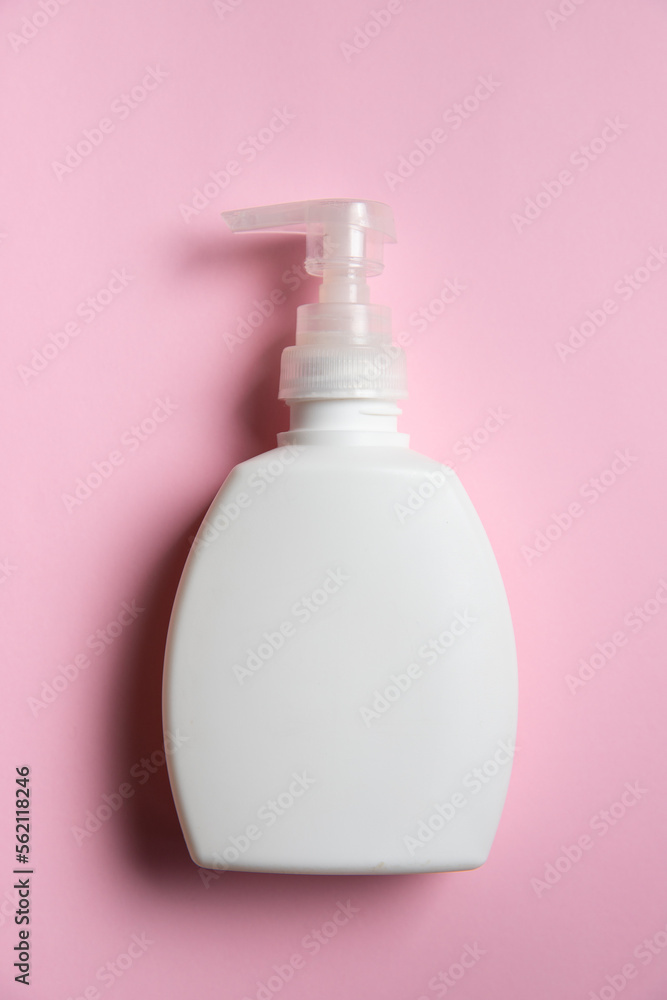 The white clear liquid soap bottle with dispenser on the light pink background, top view The white clear liquid soap bottle with dispenser on the light pink background, top view