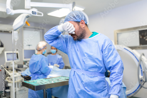 Tensed surgeon with hands on face in operating room in hospital. exhausted surgeon after long surgery