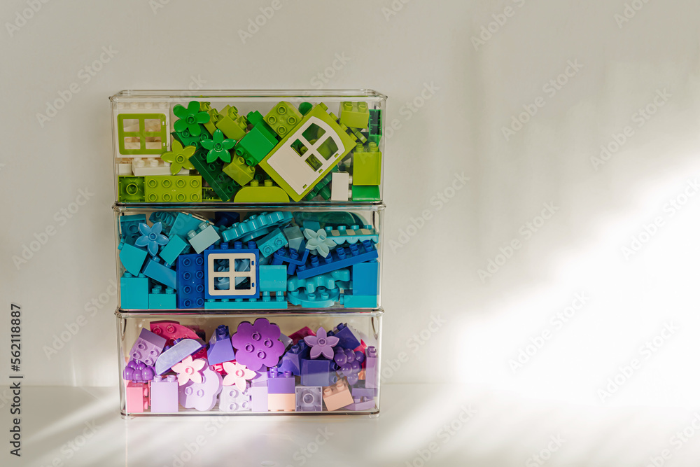 Fototapeta premium Bricks duplo. Bricks sorting by colors in transparent plastic containers. Storage Ideas in nursery. Space organizing at children's room.