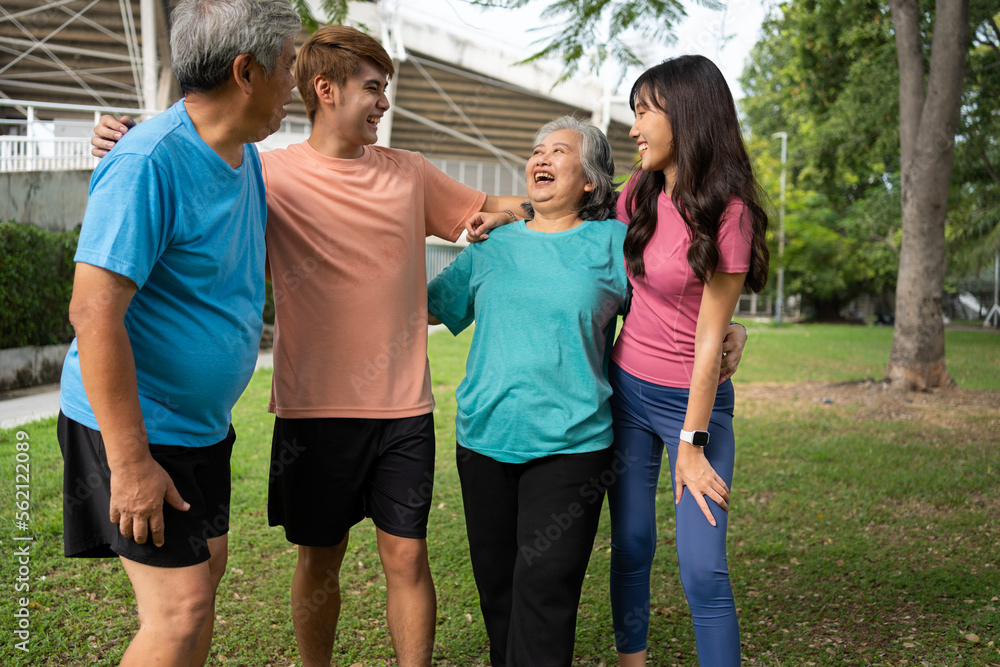 Healthy family group instructors workout in fresh air, and they rest and stand together after morning exercises in park. Outdoor activities, healthy lifestyle, strong bodies, fit figures, health care.