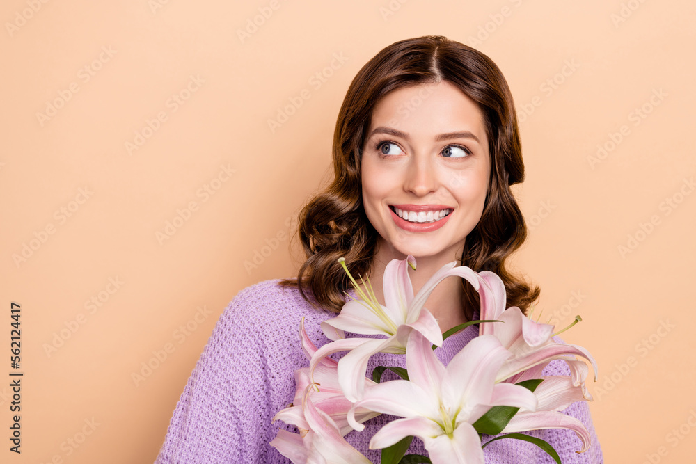 Photo of gorgeous cheerful woman with curly hairdo wear knit sweater hold flowers look empty space isolated on beige color background Photo of gorgeous cheerful woman with curly hairdo wear knit sweater hold flowers look empty space isolated on beige color background