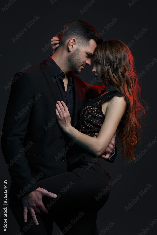A couple in love hugging on a black background.