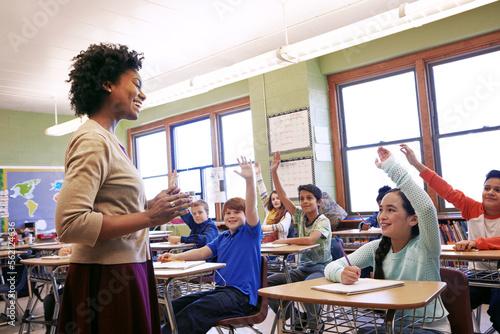 Fotografie School, teacher and children raise their hands to ask or answer an academic question for learning