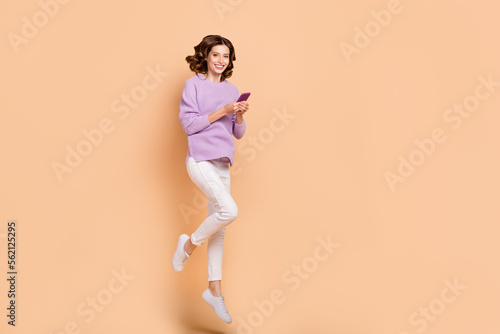Full length photo of adorable lovely lady wear purple trendy outfit bought use modern device empty space isolated on beige color background