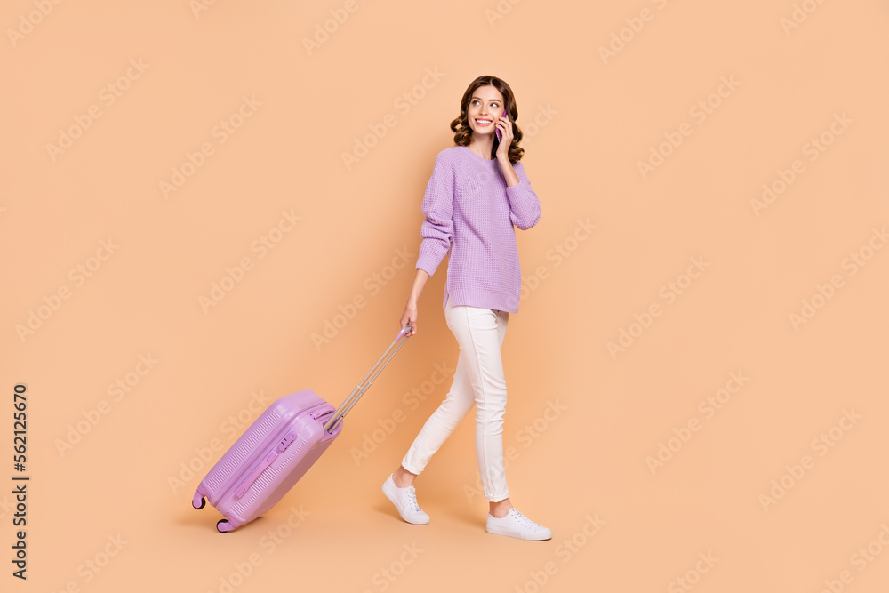 Full length photo of charming lady speak telephone booking service reserve taxi hotel look empty space isolated on beige color background Full length photo of charming lady speak telephone booking service reserve taxi hotel look empty space isolated on beige color background