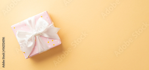 St Valentine's Day concept. Top view photo of pastel pink present box with white ribbon bow on isolated pastel beige background with copyspace © ActionGP