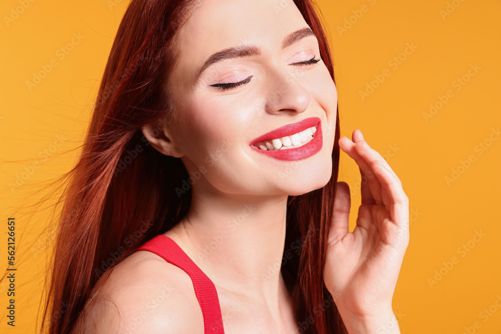 Happy woman with red dyed hair on orange background Happy woman with red dyed hair on orange background