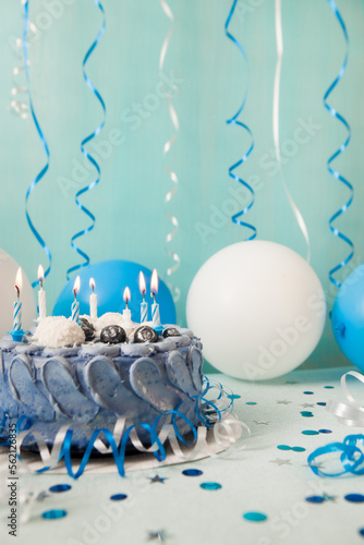 Blue cake with candles and white and navy air balloons, happy birthday vertical card