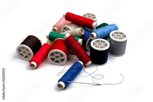 group of sewing spools and two needles isolated on white background with real shadows