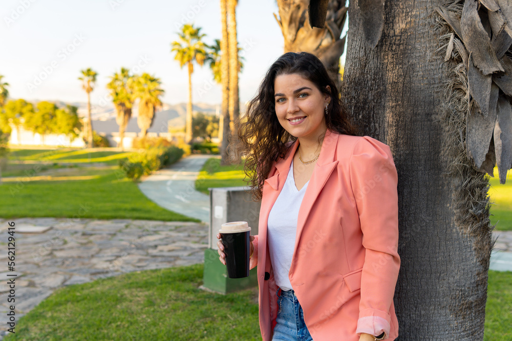 Naklejka premium Well-dressed young girl, holding her glass of coffee.